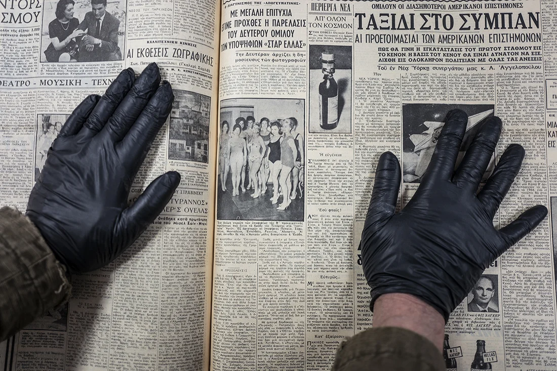 He presents the photograph and article that interest him in order to photograph them. To avoid getting ink on his hands, he wears protective gloves.