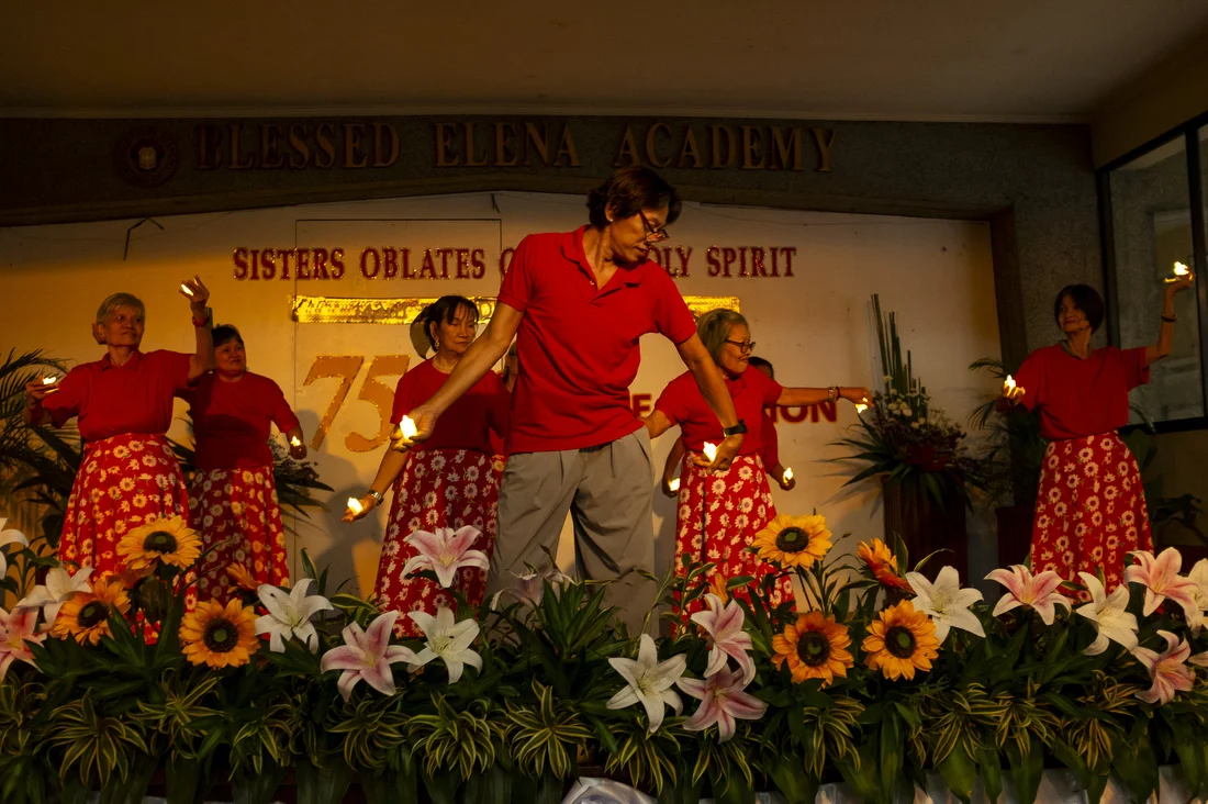 Rey Ravago (65) leads a group of elderly women in Pandanggo sa Ilaw, a traditional Filipino dance, during a church mission event.