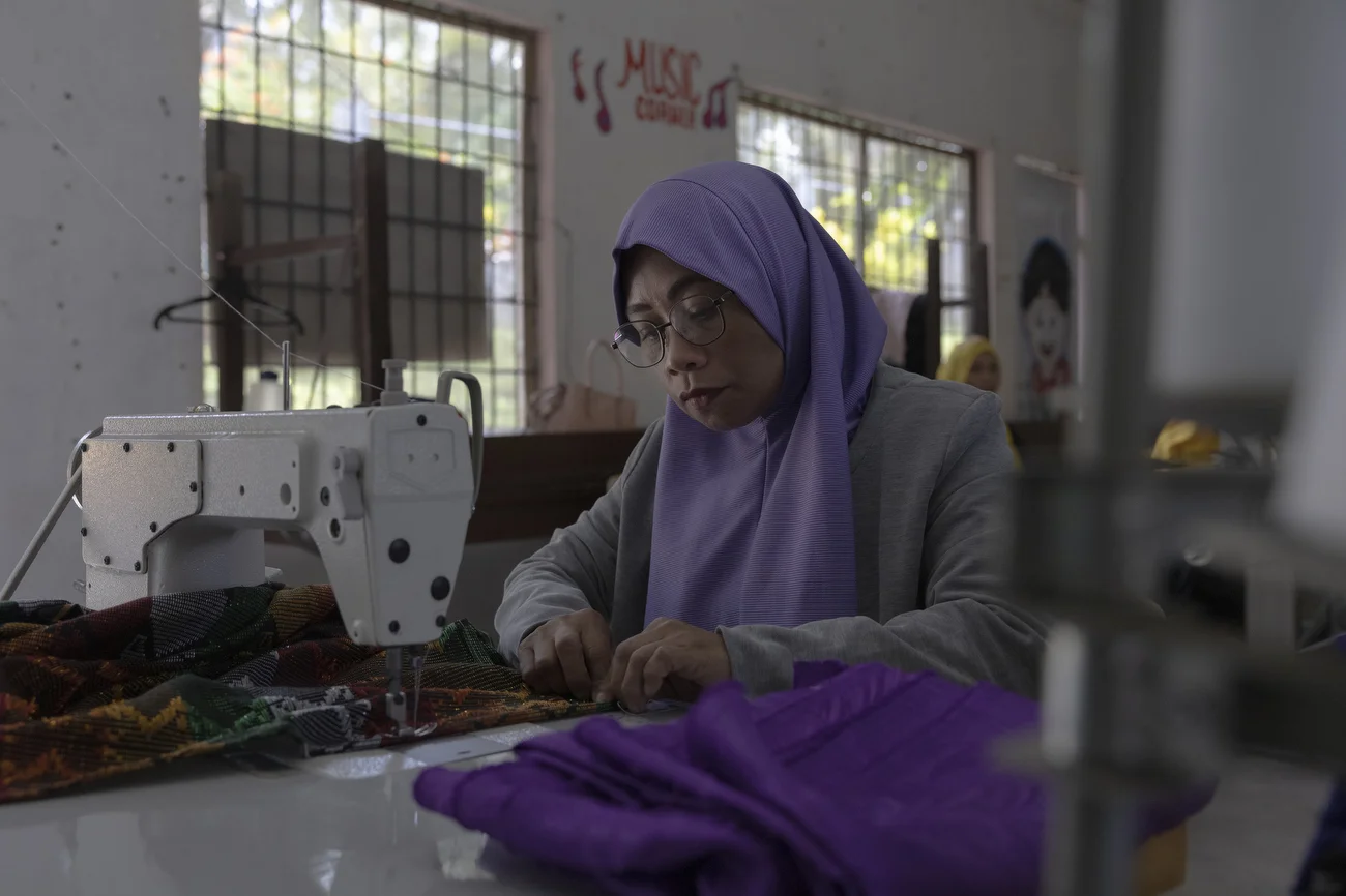 Ribadiva Fiang tailors traditional dresses as part of NIFIA’s livelihood program. With training and support from the Mahintana Foundation and GCERF, she developed a source of income that helps support her children.