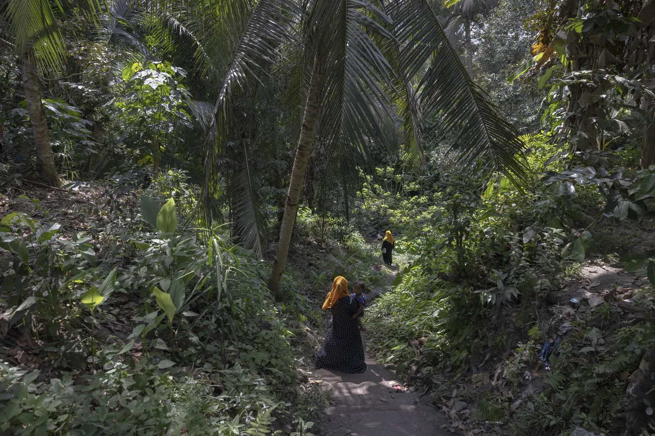 Rahima Kanebpel collects water near her home and tends her family garden. As a widow, she cares for her children and occasionally helps NIFIA by preparing Kagikit, a Maranao dish sold by the group.