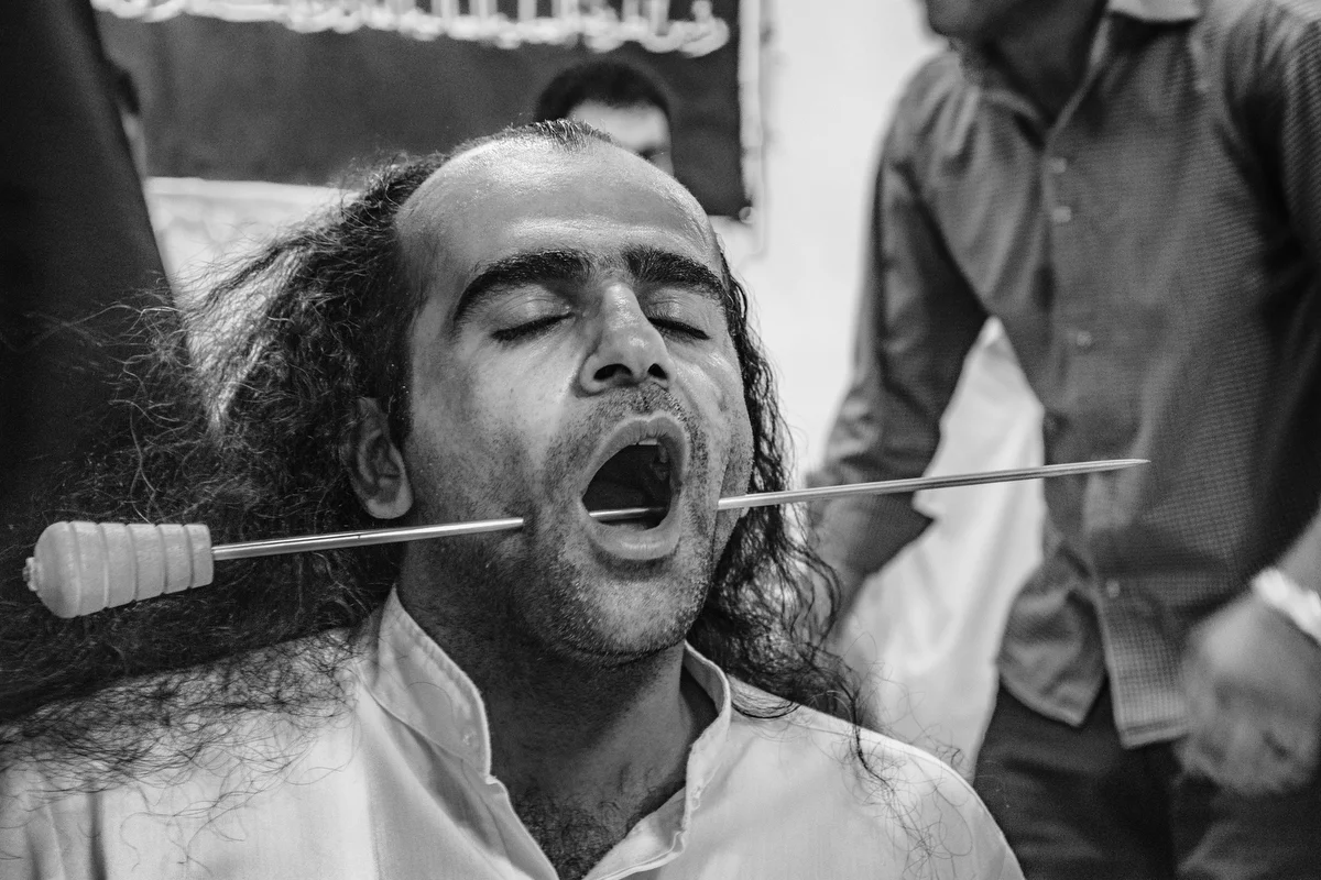 Dervish with a dagger piercing his cheek during Dhikr and The Caliph helps him.