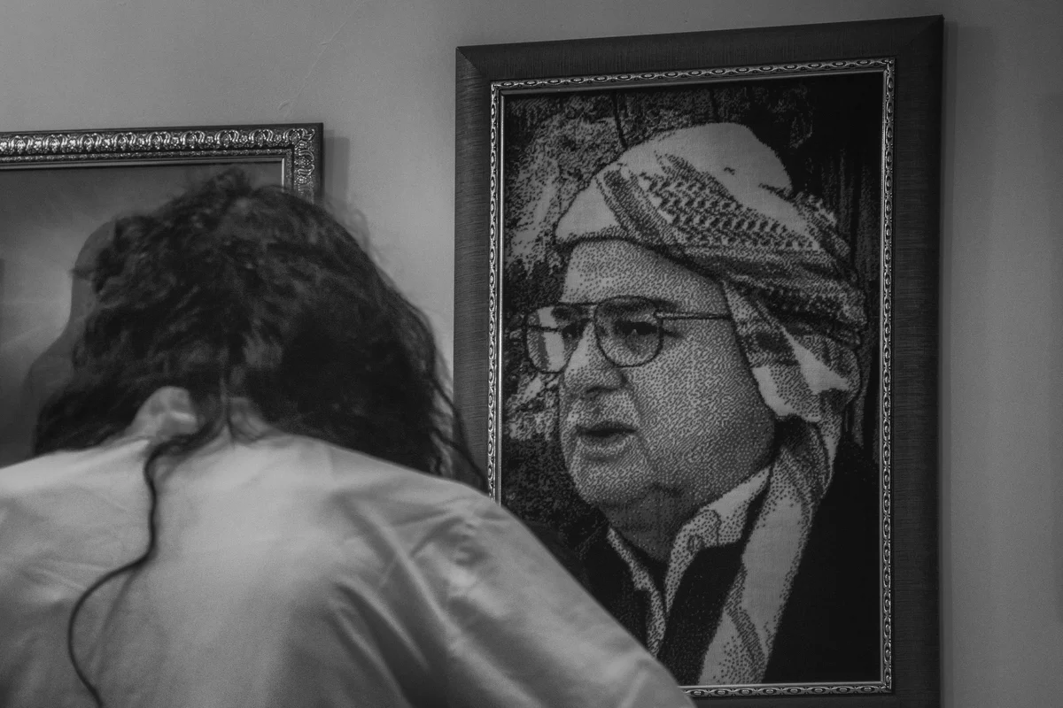 A framed picture of Sheikh Mohammad Kasenzani hangs on the Tekye wall, while a dervish looks at it. The arrangement follows a spiritual hierarchy and hierarchical structure