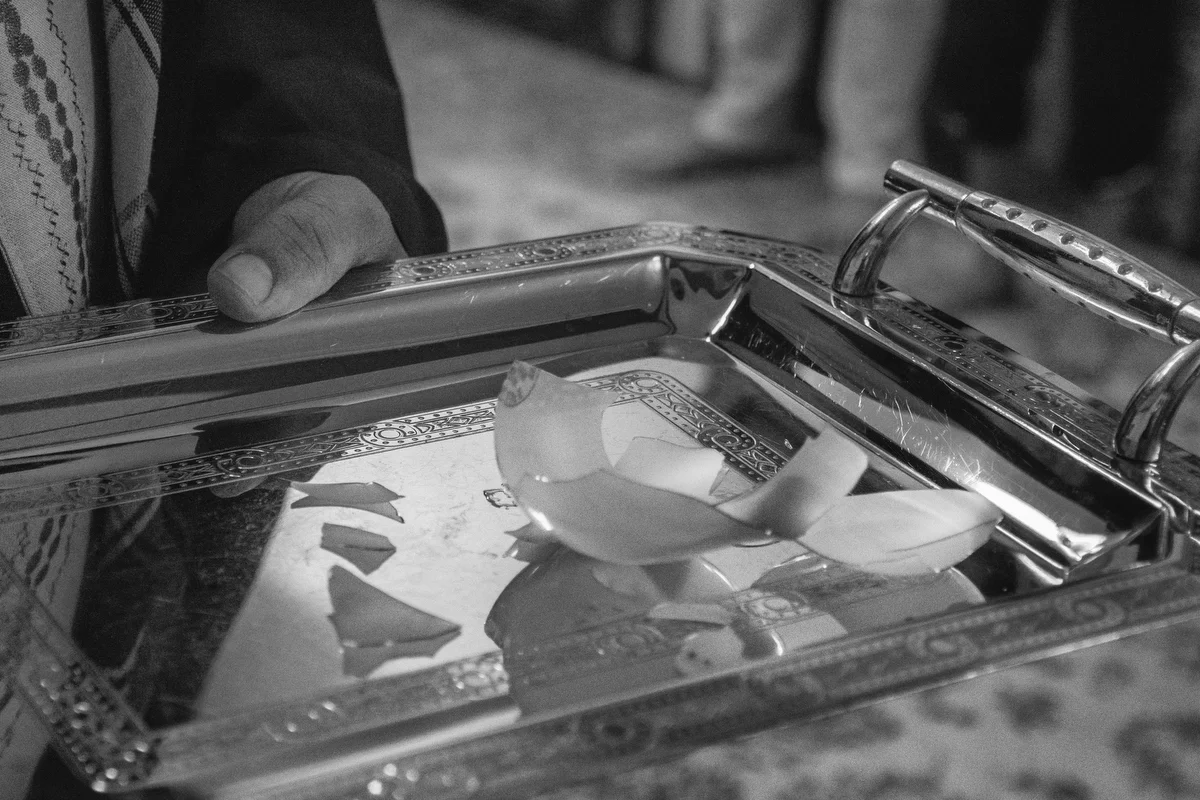 The Caliph holds a broken glass to his chest during the ceremony.