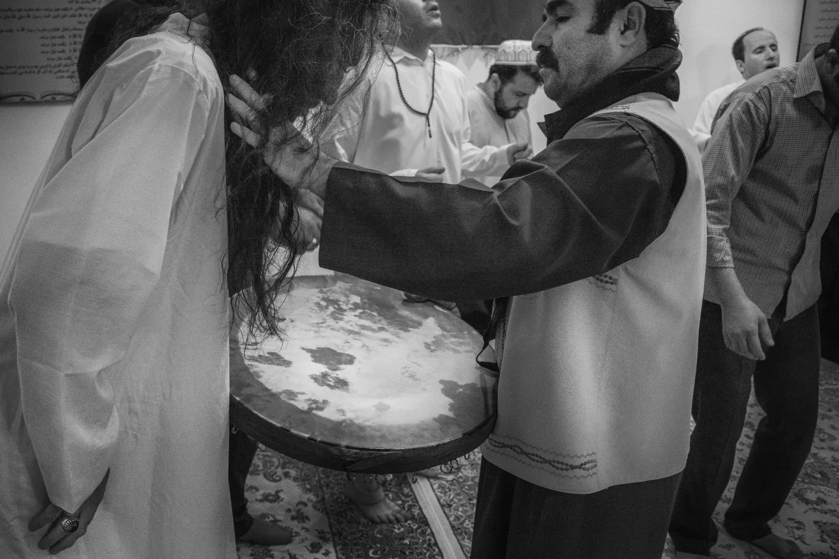 The Caliph helps the dervish after chewing on a blade during the ceremony.