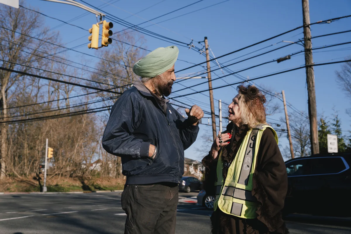 Paulette Dorflaufer speaks with Resham Singh, a worker at the Exxon gas station where her crossing guard shift takes place in Livingston, NJ .