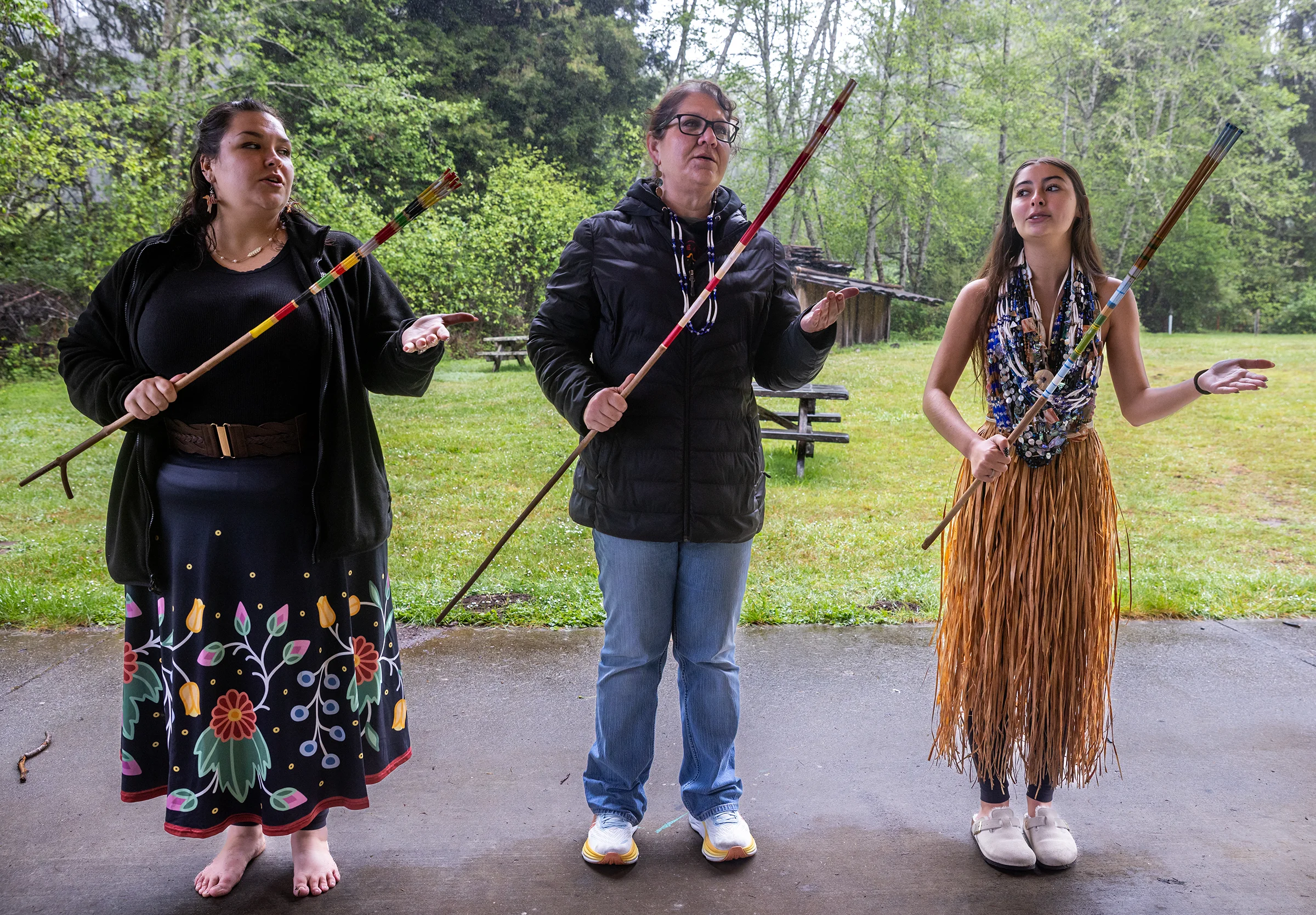 A youth sings with her aunt, an elder, as teachings about dance, regalia, and ceremony are shared. The moment reflects cultural knowledge being passed through family, song, story, and participation.