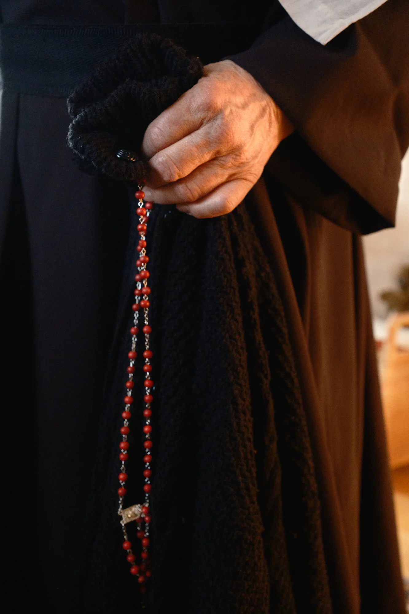 Sister Rita's hand as she holds her sweater and her rosary. Elsbethen, Austria, Mar 20, 2026.