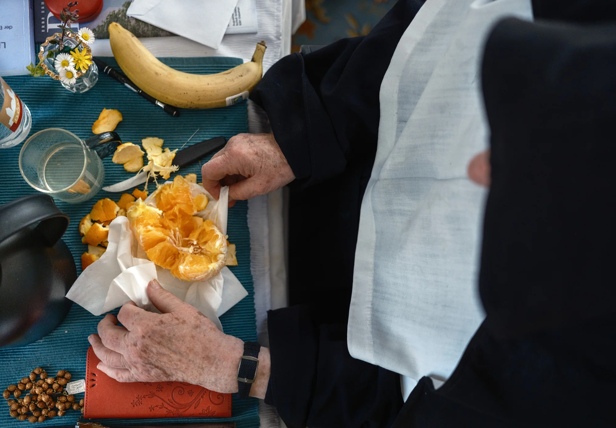 Sister Bernadette prepares an orange and a banana to gift to two girls at the Schloss Goldenstein school who helped her paint a rather large Easter egg.