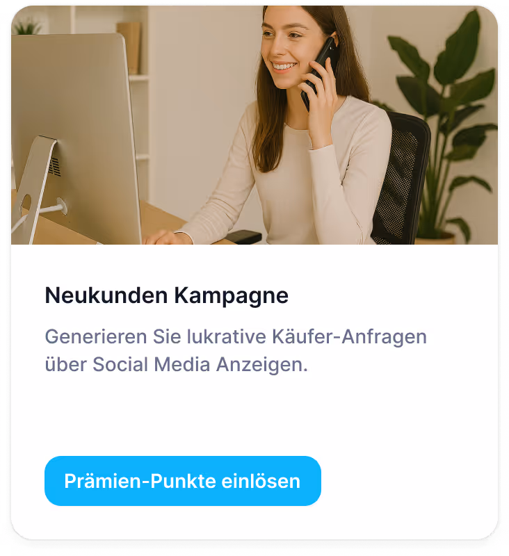 Smiling woman sitting at desk, talking on phone and looking at a computer screen in a bright office.