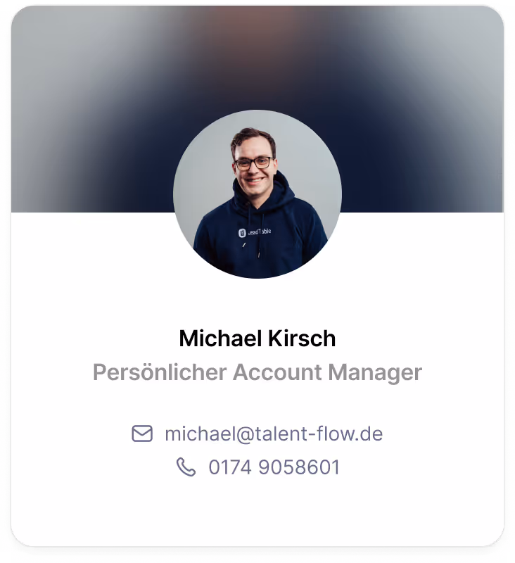 Portrait of Michael Kirsch wearing glasses and a dark hoodie, smiling against a blurred background.