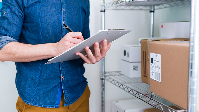 shared services inventory management, man holding clipboard, ballpen, box
