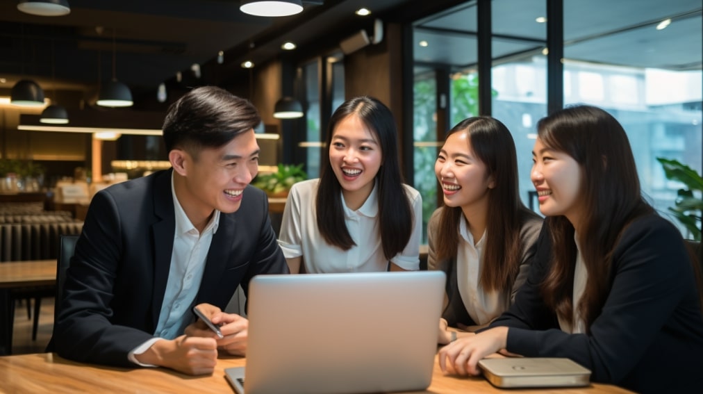 A dedicated bpo team, comprised of five diligent Asian staff members, working diligently inside the office with a laptop on.