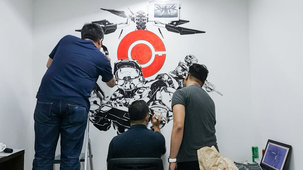 three people painting on a wall 