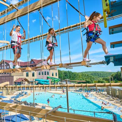 Father and kids are walking across the high ropes course