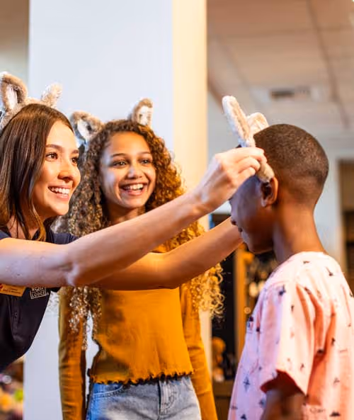 Pack member placing wolf ears on boy while sister looks on
