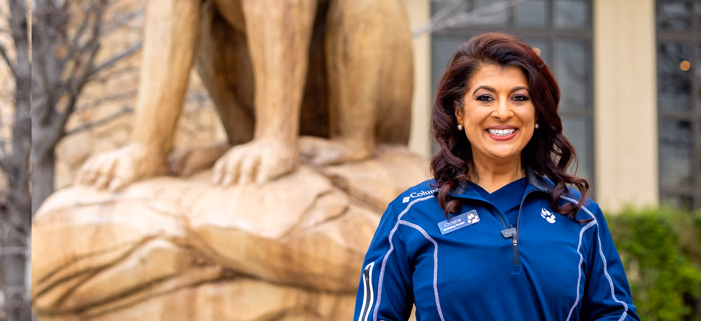 Dr. Romie Mushtaq posing in front of GWL Statue