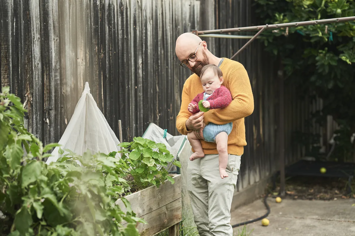A dad playing with daughter in a backyard
