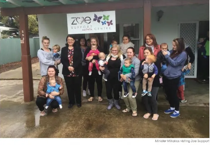 Women gather around a building holding their children