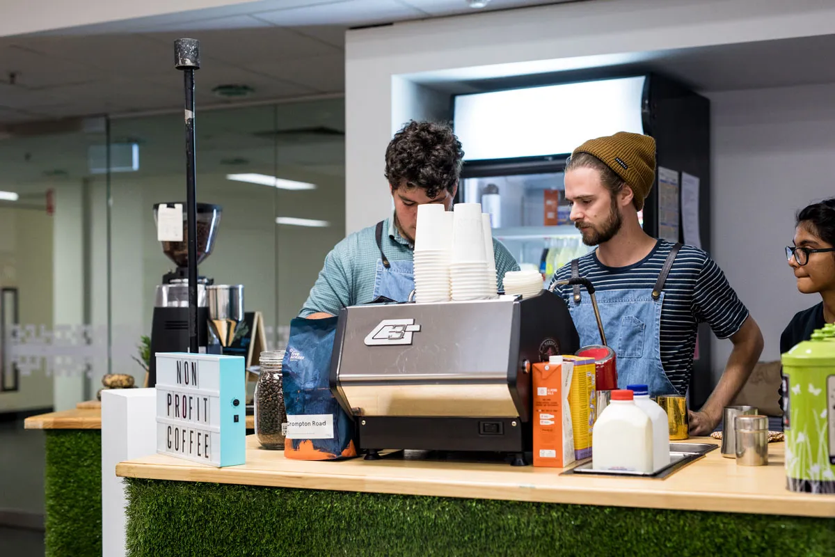 People work behind the counter, making coffee