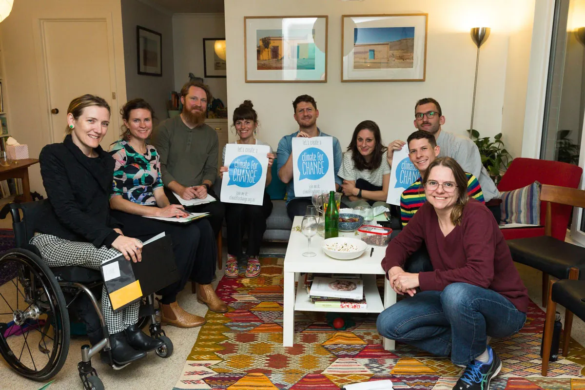 Climate for Climate team sit together for a photo, they hold signs that read "Climate for change"