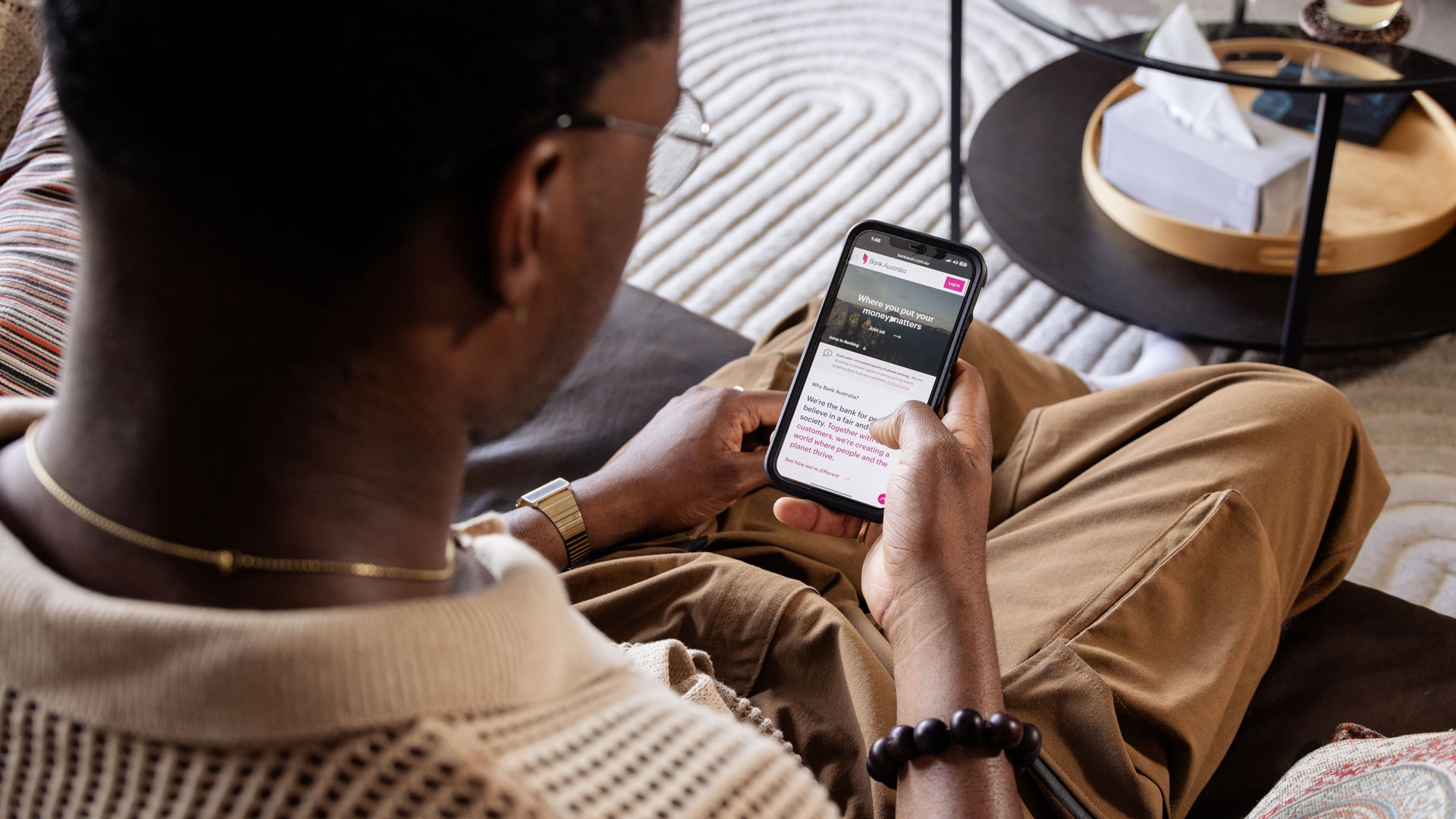 A man looks at his phone while sitting.