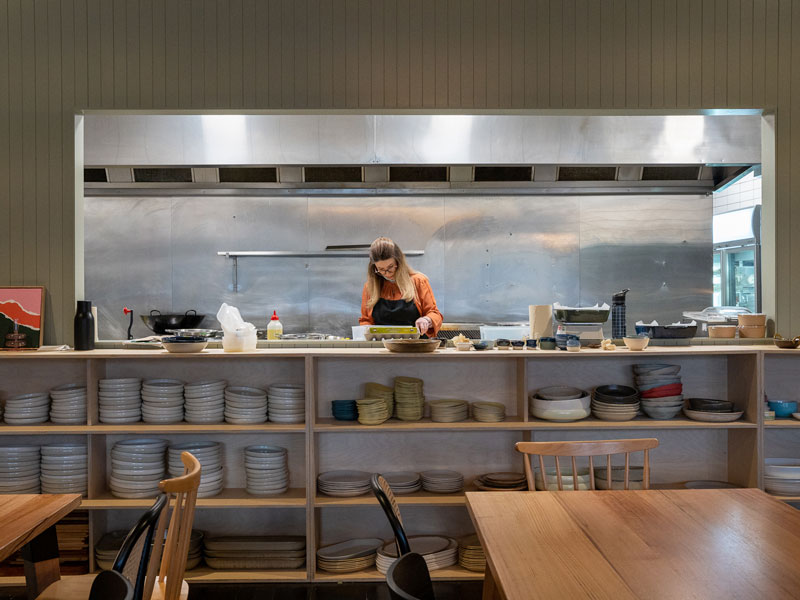 A woman cooks in a commercial kitchen