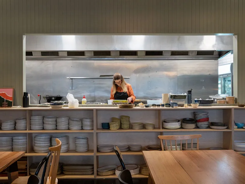 A woman cooks in a commercial kitchen
