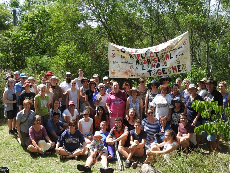 A large group of people sit and stand together outside