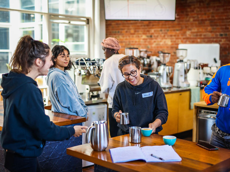 Students gather around and learn how to brew coffee