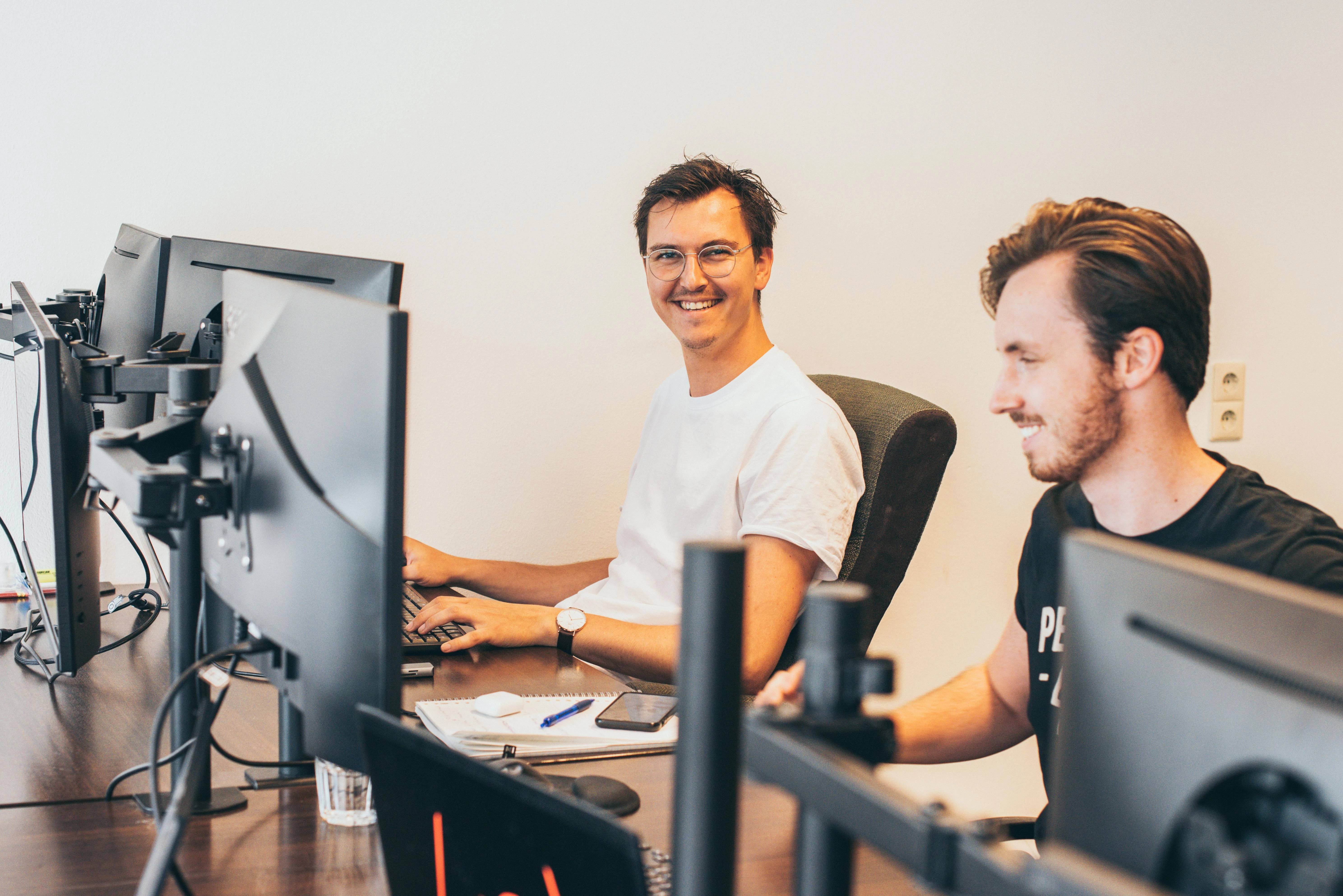 debo teammembers behind computer smiling