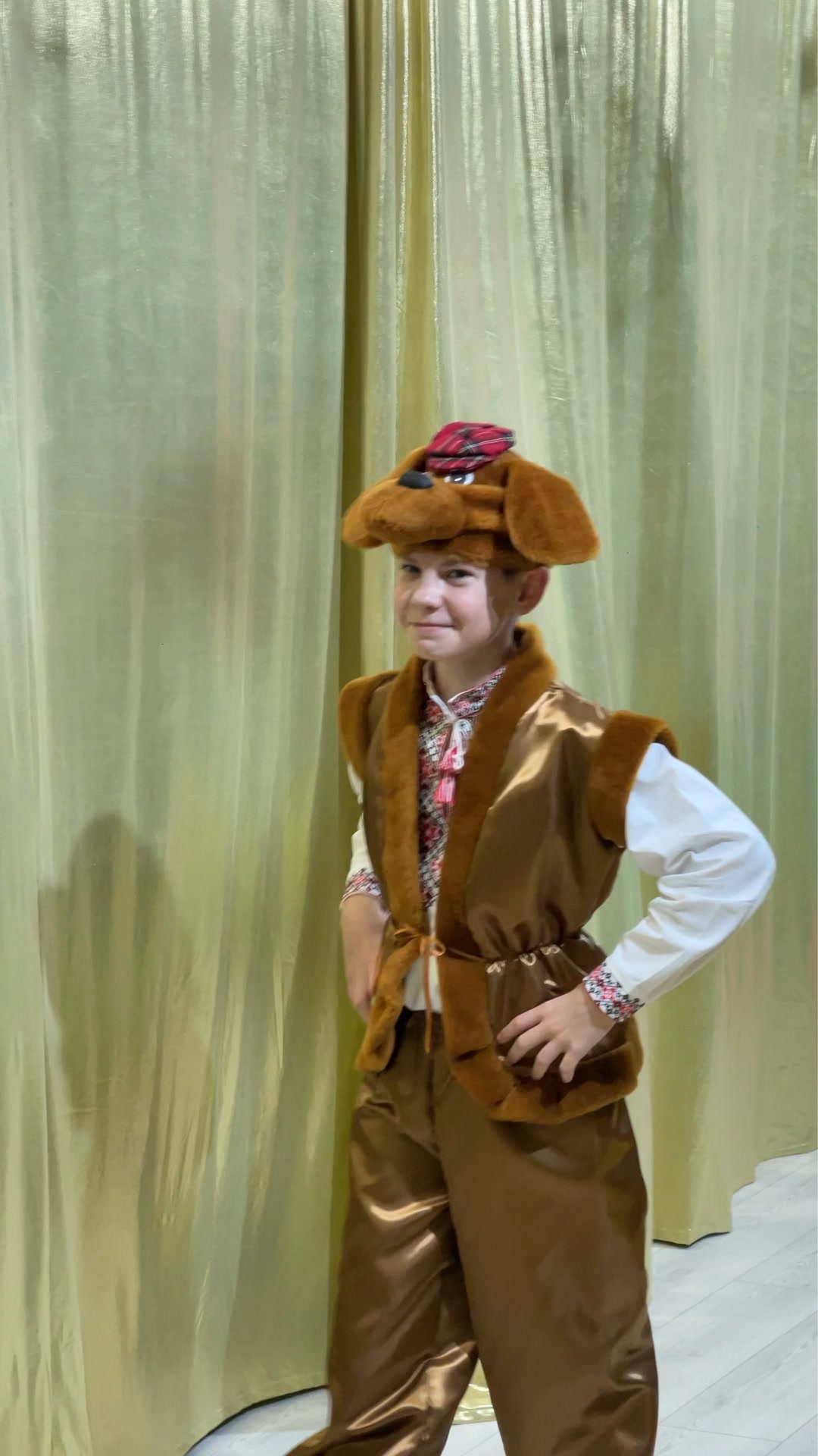 Ein Junge in einem Bauernkostüm auf dem Hintergrund eines goldenen Hintergrunds während einer Aufführung in der Schule „Kinder der Zukunft“