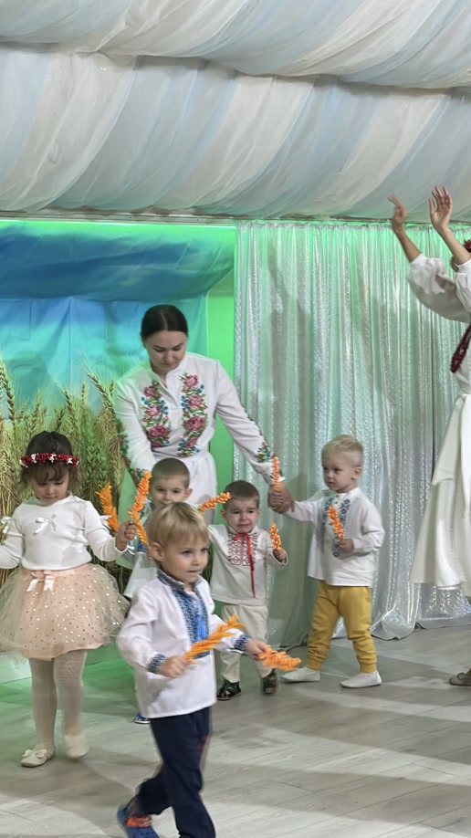Kinder in Nationalkostümen auf der Bühne der Schule „Kinder der Zukunft“
