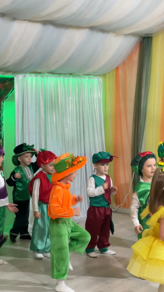 Jungen in Kostümen aus Karotten und anderem Gemüse auf der Bühne der Schule „Kinder der Zukunft“