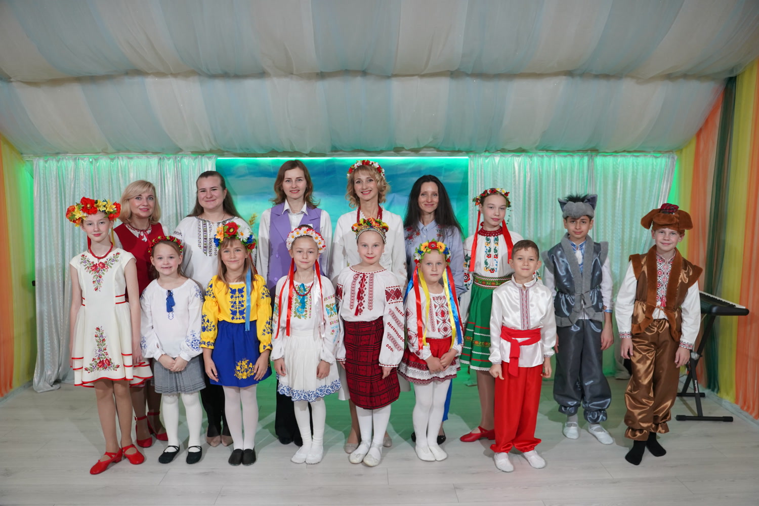 Schüler in leuchtend bestickten Hemden und Bühnenkostümen stellten sich für eine Aufführung an der Schule „Kinder der Zukunft“ auf