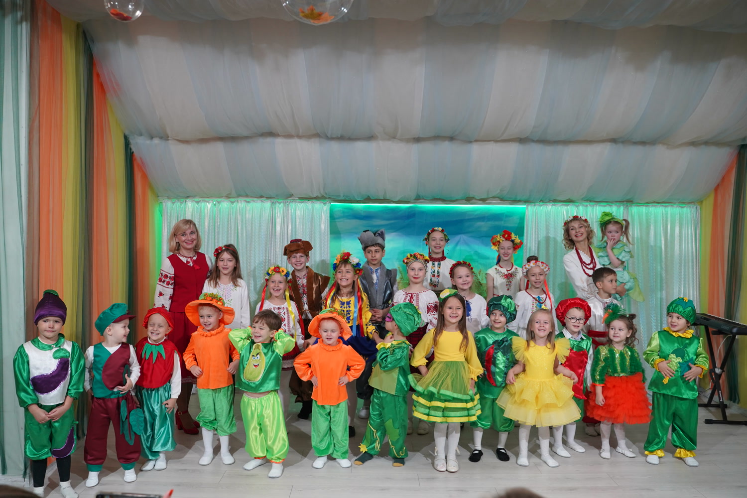 Grundschüler der Schule „Kinder der Zukunft“ in Gemüsekostümen auf der Bühne während des Herbstfestes