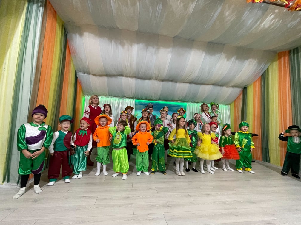 Farbenfrohe Aufführung von Kindern in leuchtenden Gemüsekostümen in den Herbstferien in der Schule „Kinder der Zukunft“