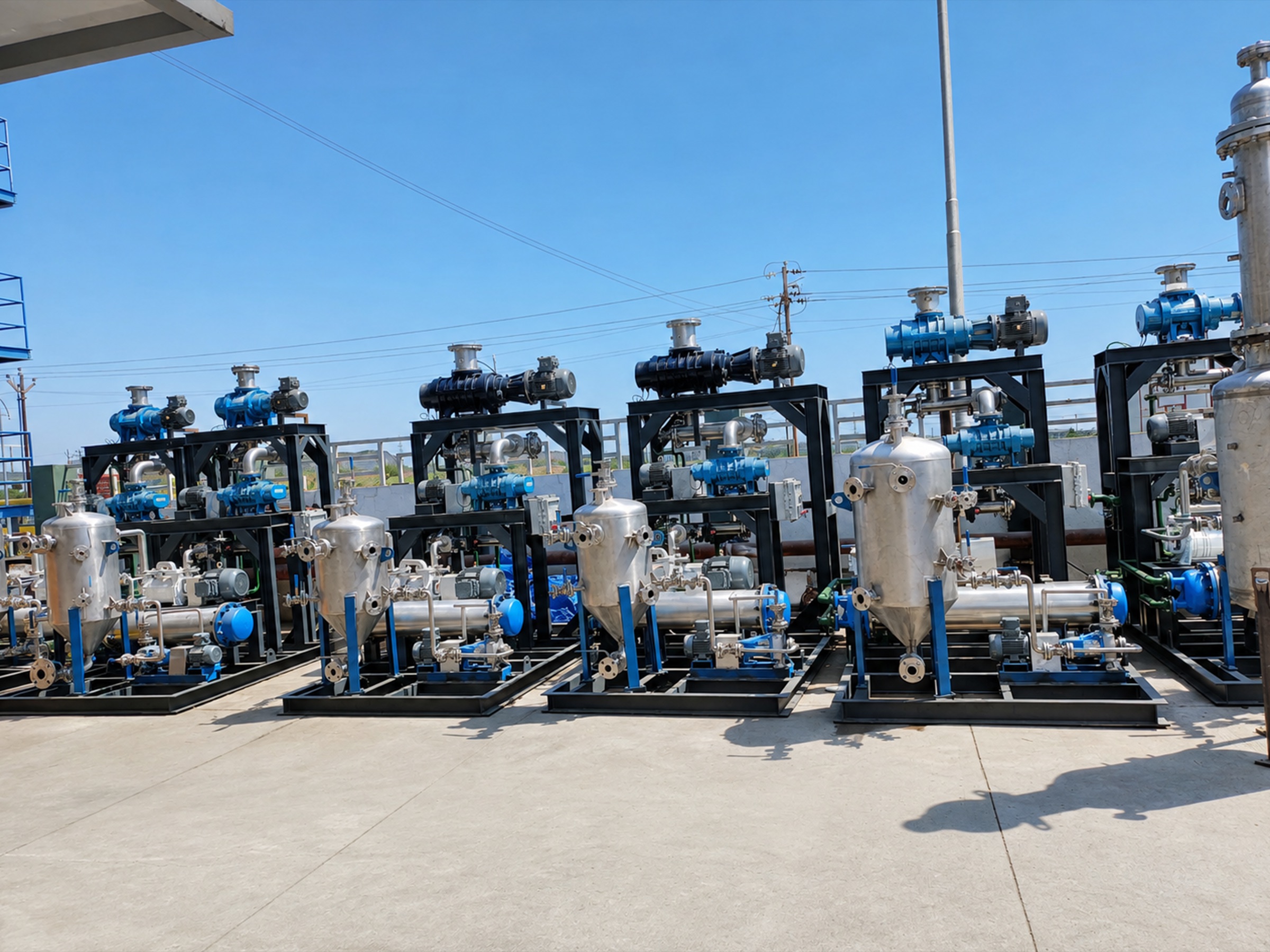 Row of skid-mounted vacuum pump units with stainless steel separator vessels