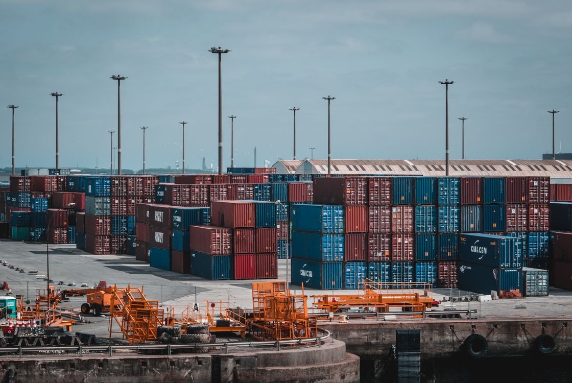 Stacked shipping containers and handling equipment in a port container yard