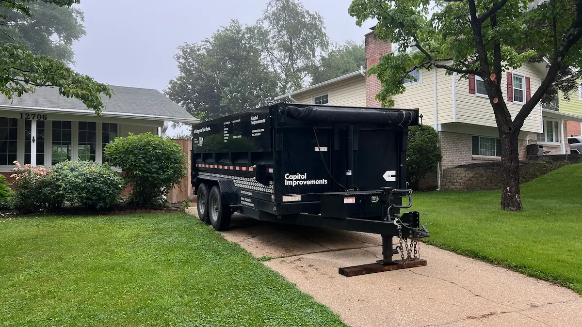 Capitol Improvements dump trailer at Silver Spring MD roofing jobsite during debris cleanup