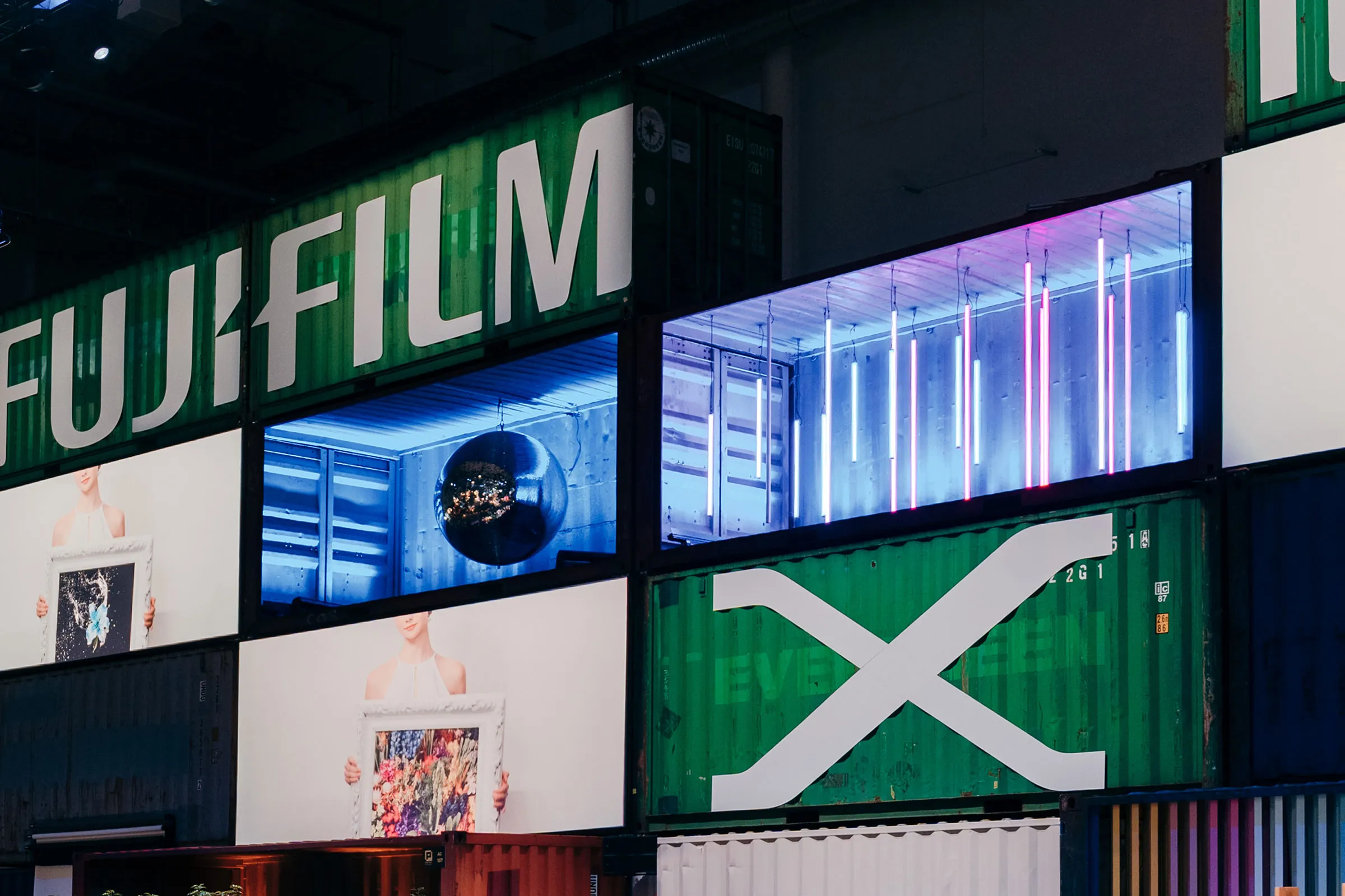 Photopia Messe. Eine Containerwand mit künstlerischen Lichtinstallationen.
