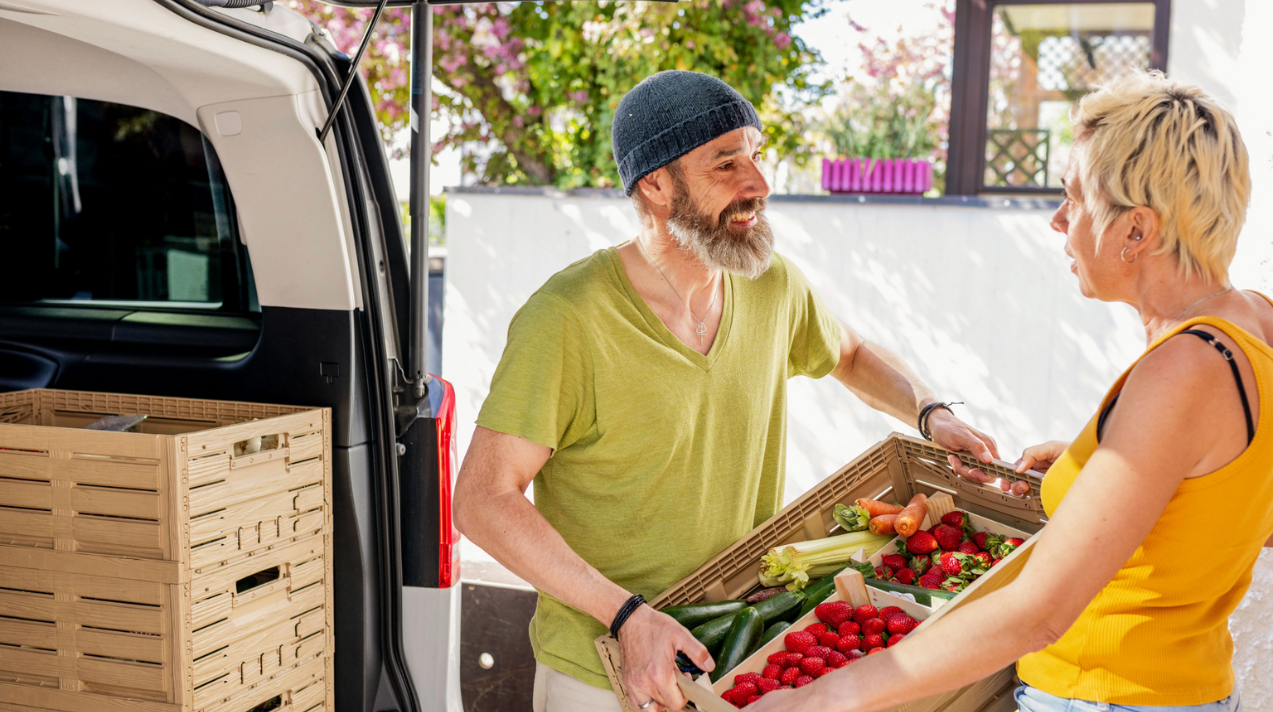 Person handing another person a produce box
