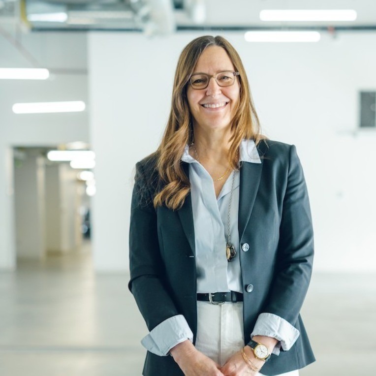 Jennifer Lussier standing in front of a white wall while inside the Platform Innovation Centre