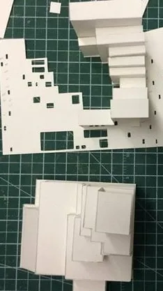 Cardstock paper being shaped into rectangular blocks sitting on top of a cutting mat