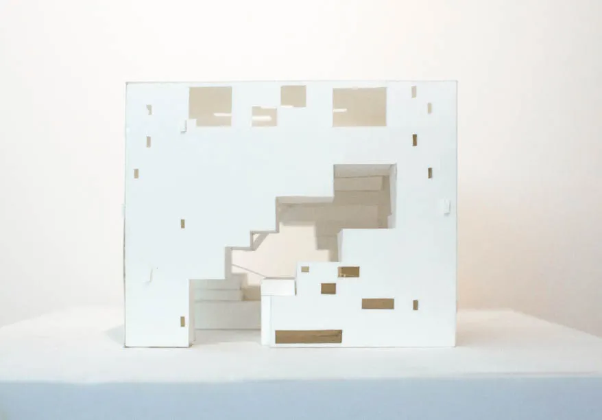 A plain paper model of the exterior facade of a rectangular building with an empty void in the middle