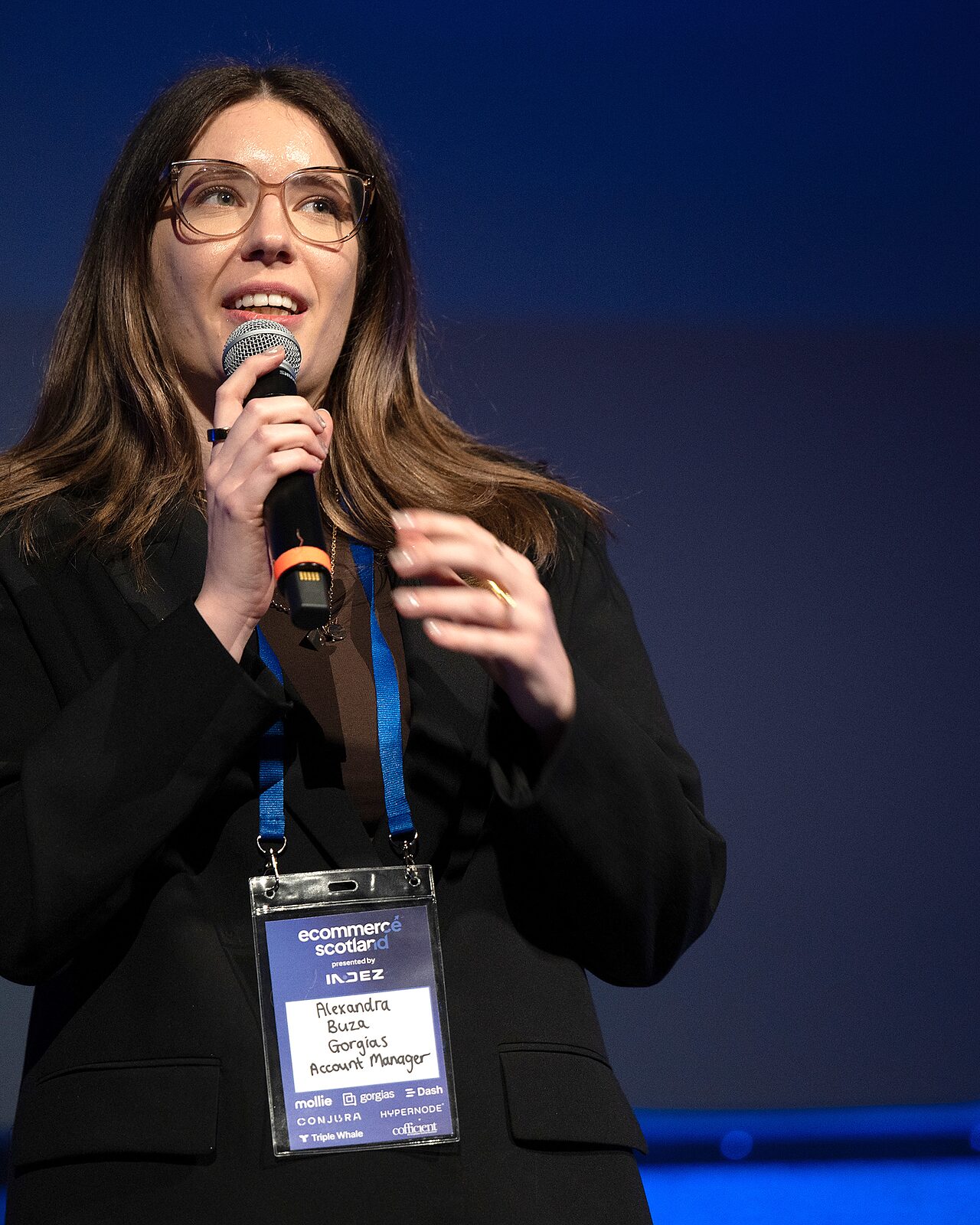 Alexandra Buza of Gorgias speaking into a hand-held microphone on the IMAX stage