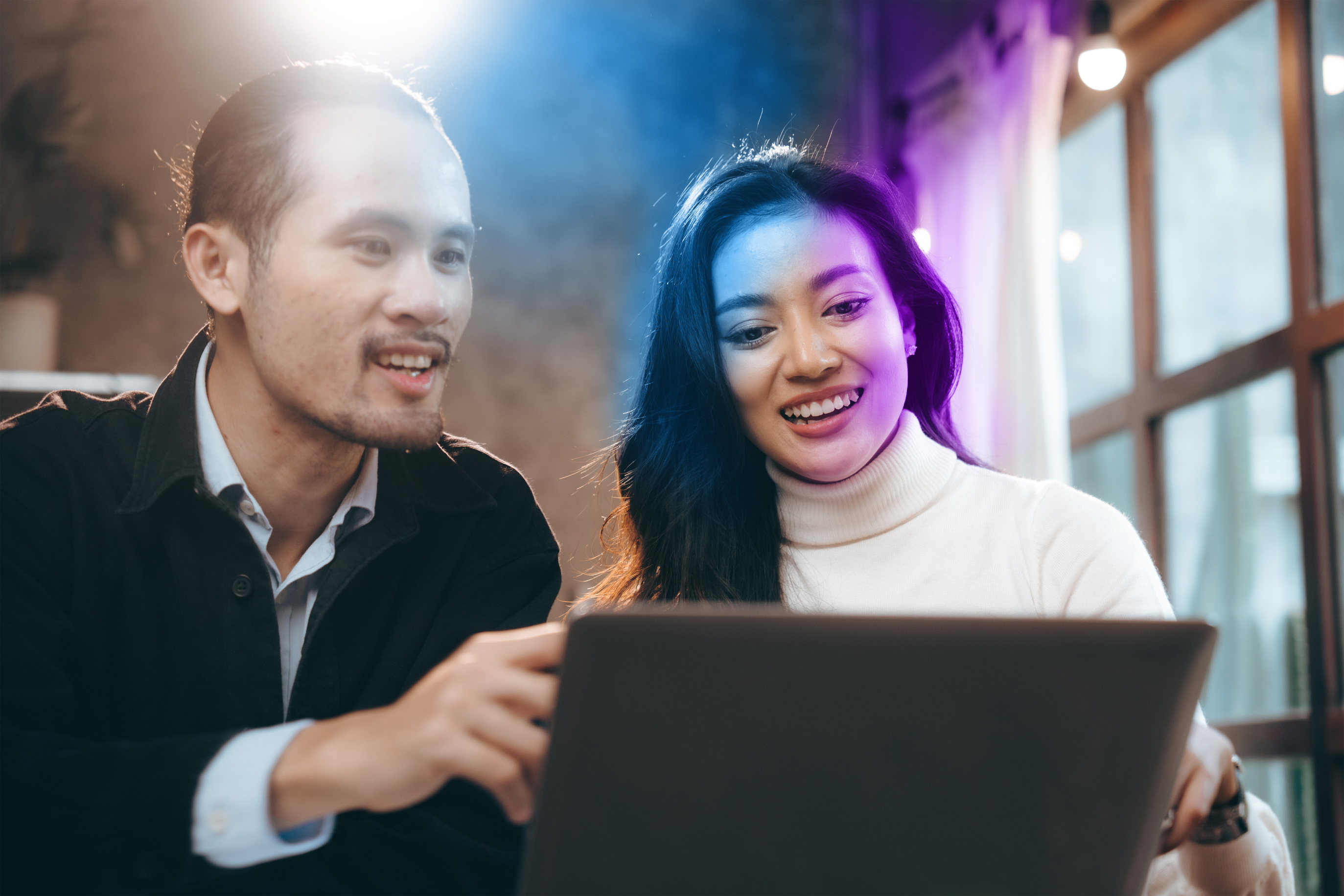 Colleagues learning at a laptop