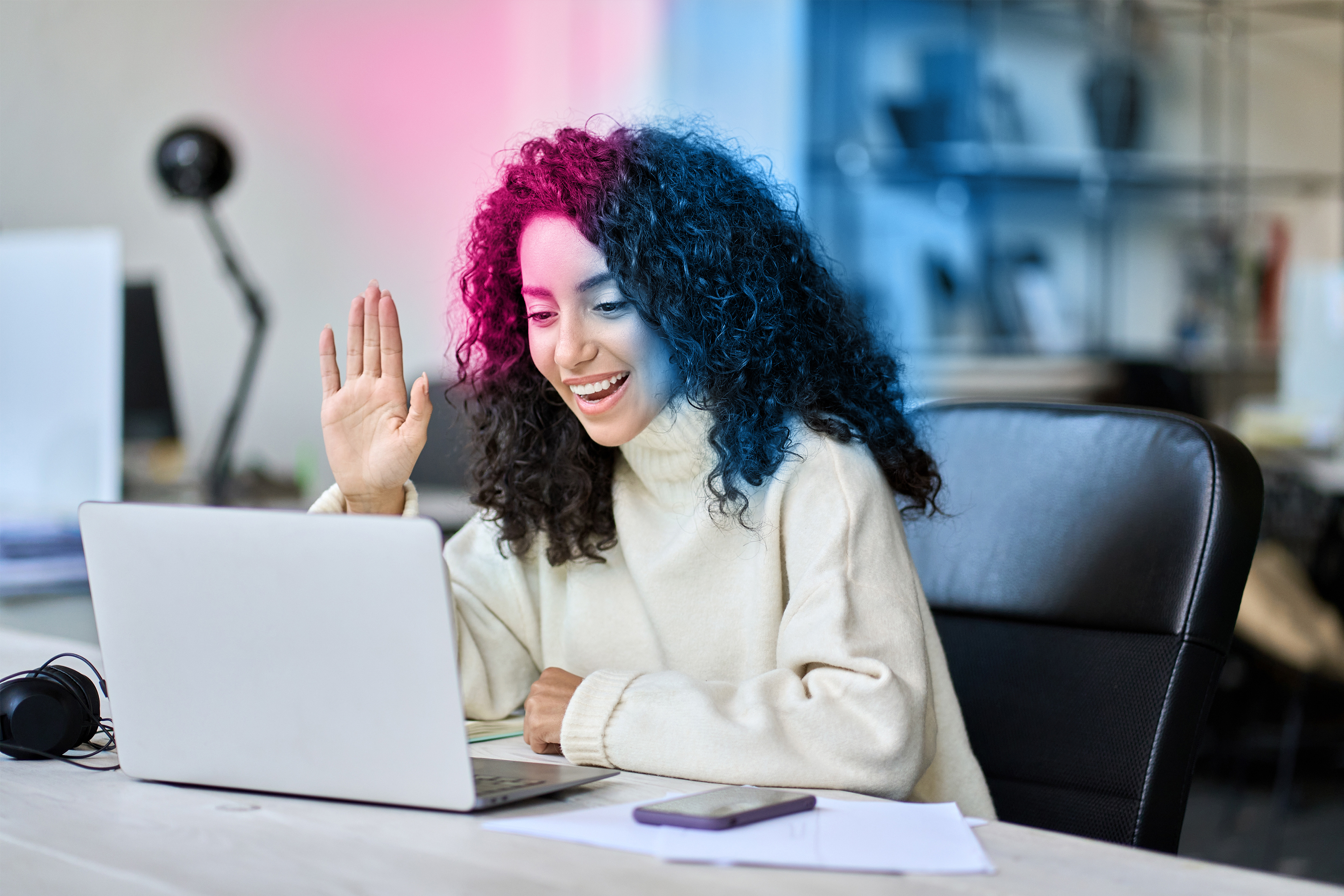 Woman attending a hybrid event from her laptop