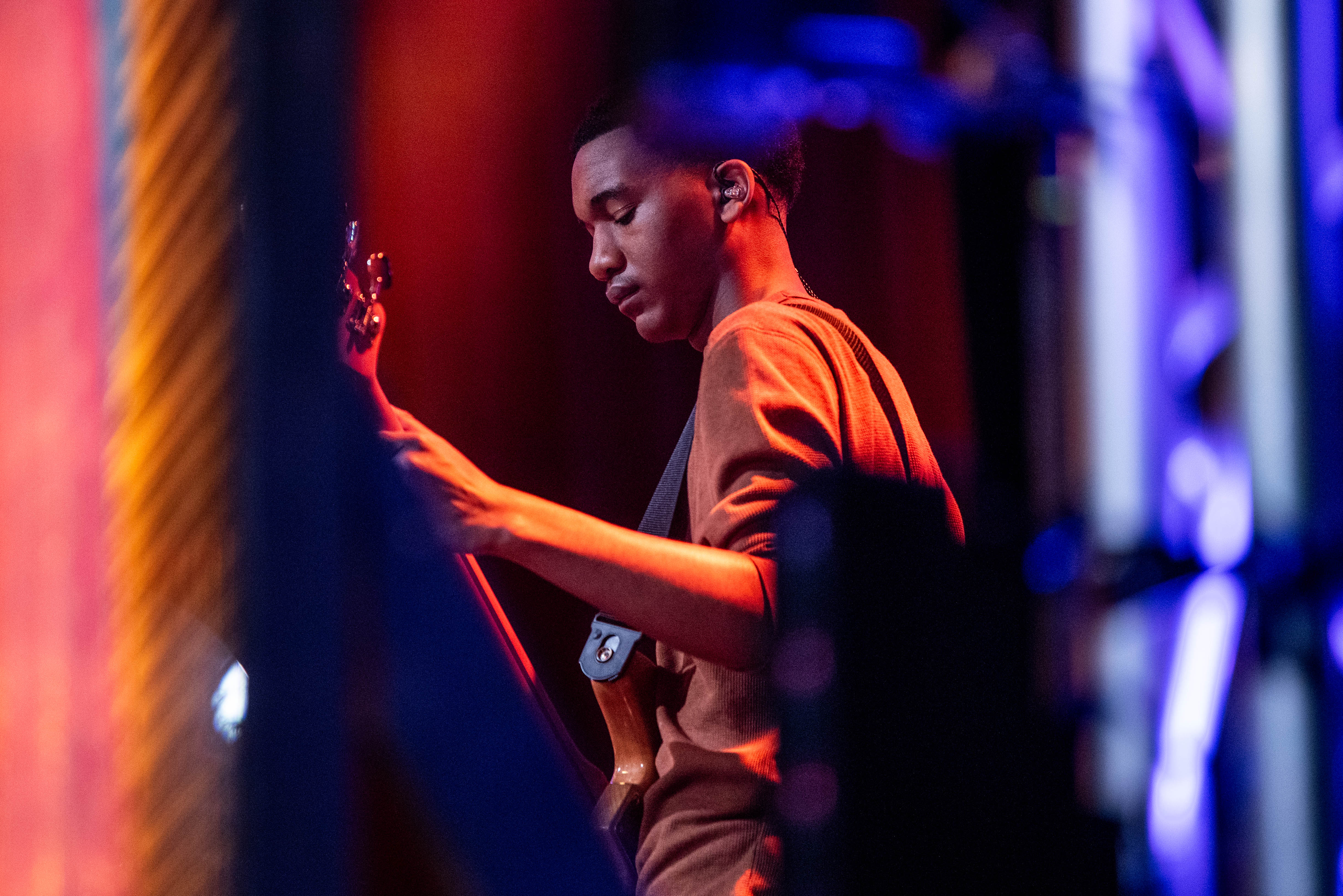 A young man playing bass on stage at church of the harvest 