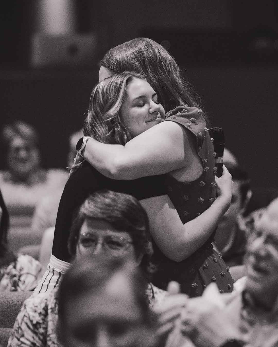 Two girls hugging after a prayer moment in service