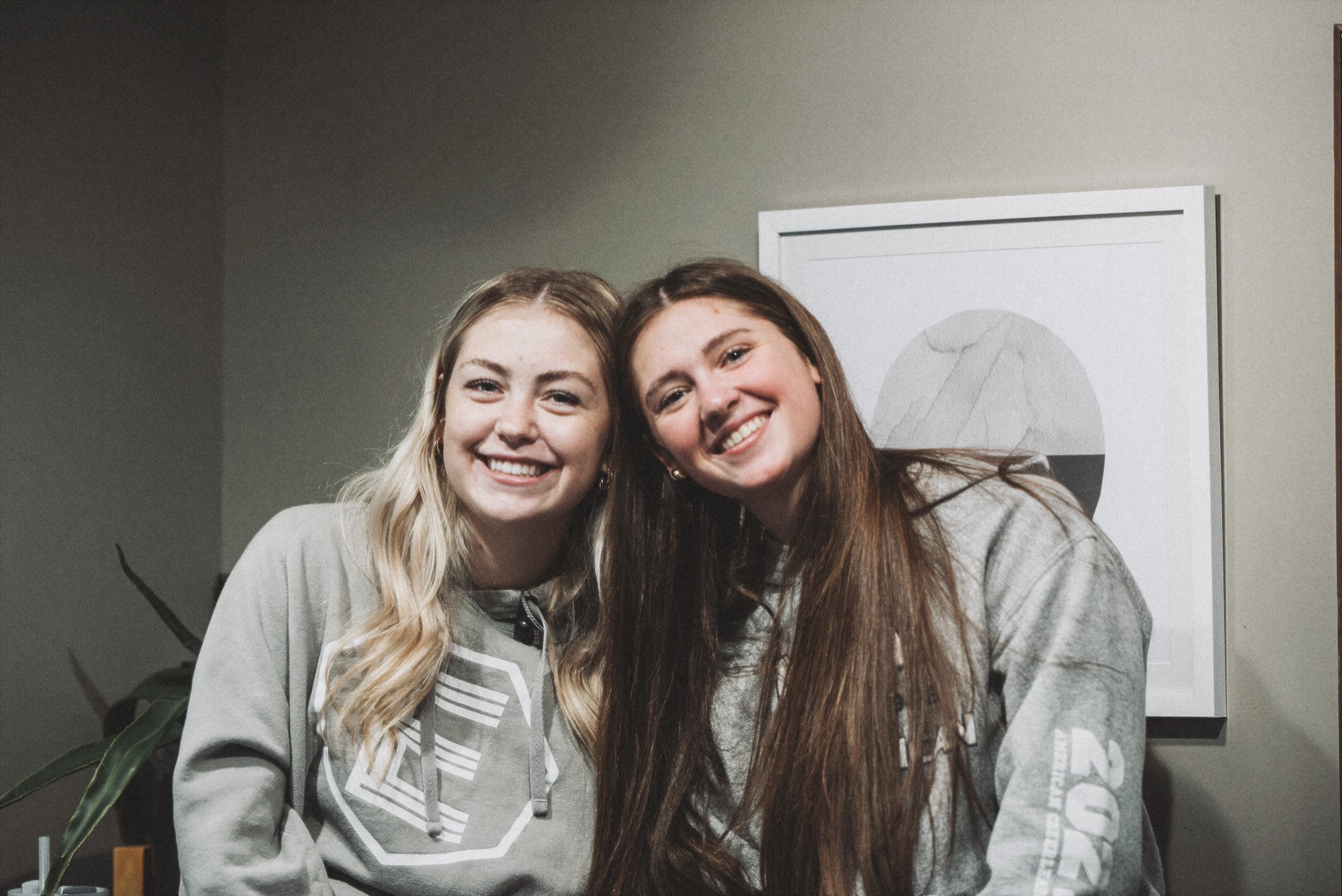 Two girls from Harvest Youth leaning against one another and smiling